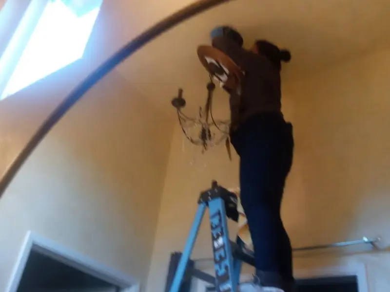Electrician installing a chandelier in a Wisconsin Dells residence